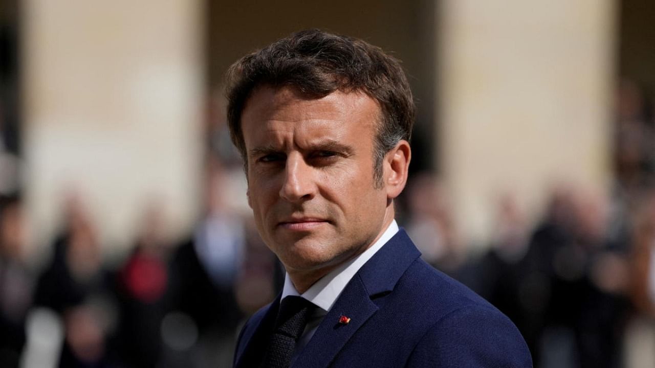 French President Emmanuel Macron reviews the troops during a national homage to late French actor Michel Bouquet at the Invalides monument in Paris. Credit: Reuters photo