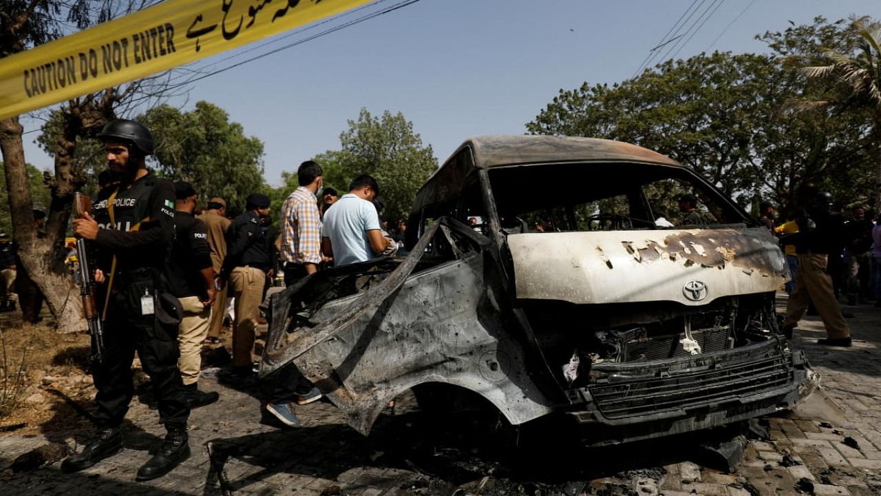 Police officers and crime scene unit gather near a passenger van, after a blast at the entrance of the Confucius Institute University of Karachi, Pakistan April 26, 2022. Credit: Reuters Photo