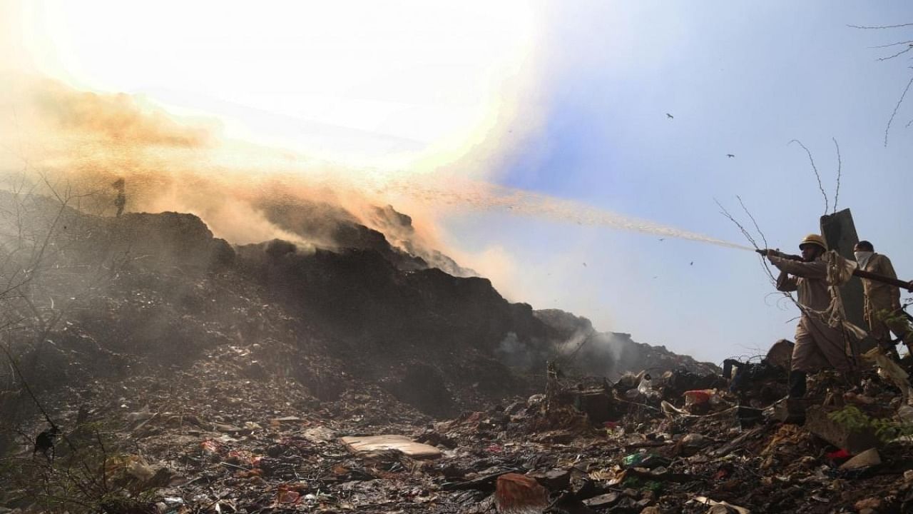 Fire fighters try to douse a fire that broke out at Bhalswa landfill site in New Delhi on Wednesday April 26, 2022. Credit: IANS Photo