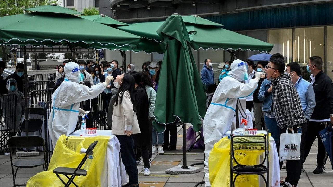 People undergo nucleic acid tests for the Covid-19 coronavirus at a makeshift testing site outside office buildings in Beijing. Credit: Reuters Photo
