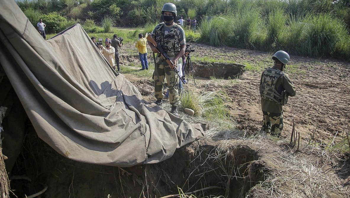 Border Security Force (BSF) personnel stand near a tunnel, originating from Pakistan, beneath the Indo-Pak international border fence, in J&K's Samba district, Saturday, Aug. 29, 2020. The force has launched a major search operation in the area to look for other such hidden structures that aid infiltration. (PTI Photo)