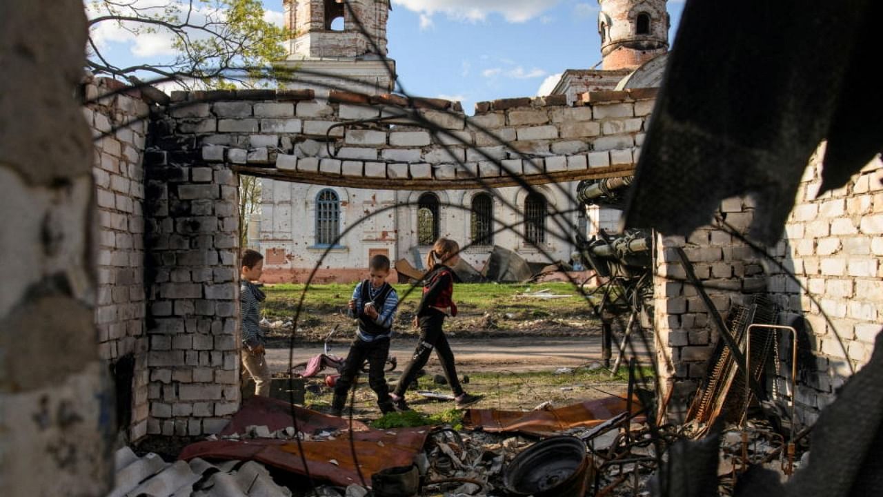 Local boys play in front of a church damaged during Russia's invasion of Ukraine, in the village of Kolychivka, in Chernihiv region, Ukraine April 27, 2022. Credit: Reuters Photo