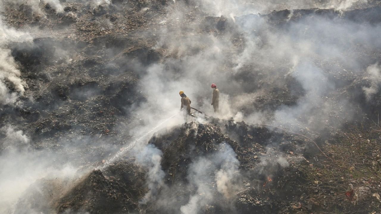 Firefighters try to douse a fire that broke out at Bhalswa landfill site, in New Delhi. Credit: PTI Photo