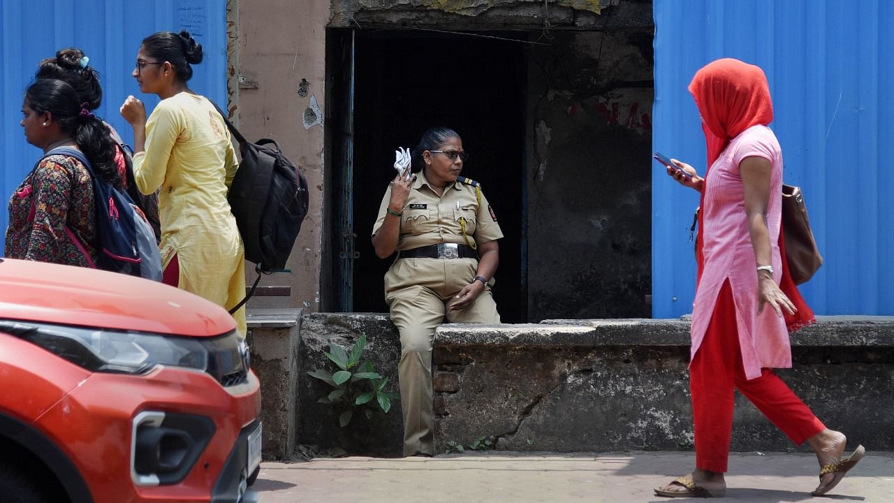 A woman constable fans herself to get respite from the heat, on a hot summer day, in Navi Mumbai. Credit: PTI File Photo