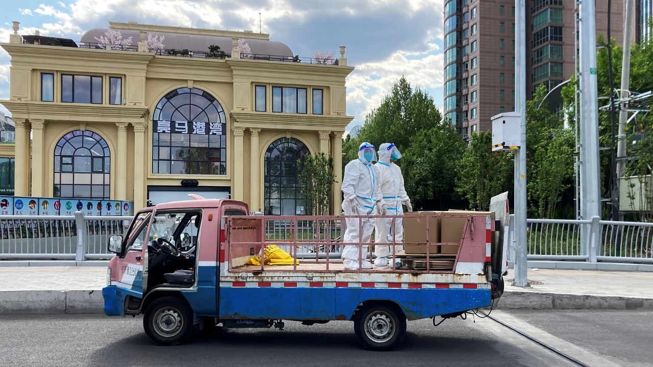 Workers in protective suits stand in a truck on a street amid the coronavirus outbreak, during the Labour Day holiday. Credit: Reuters File Photo