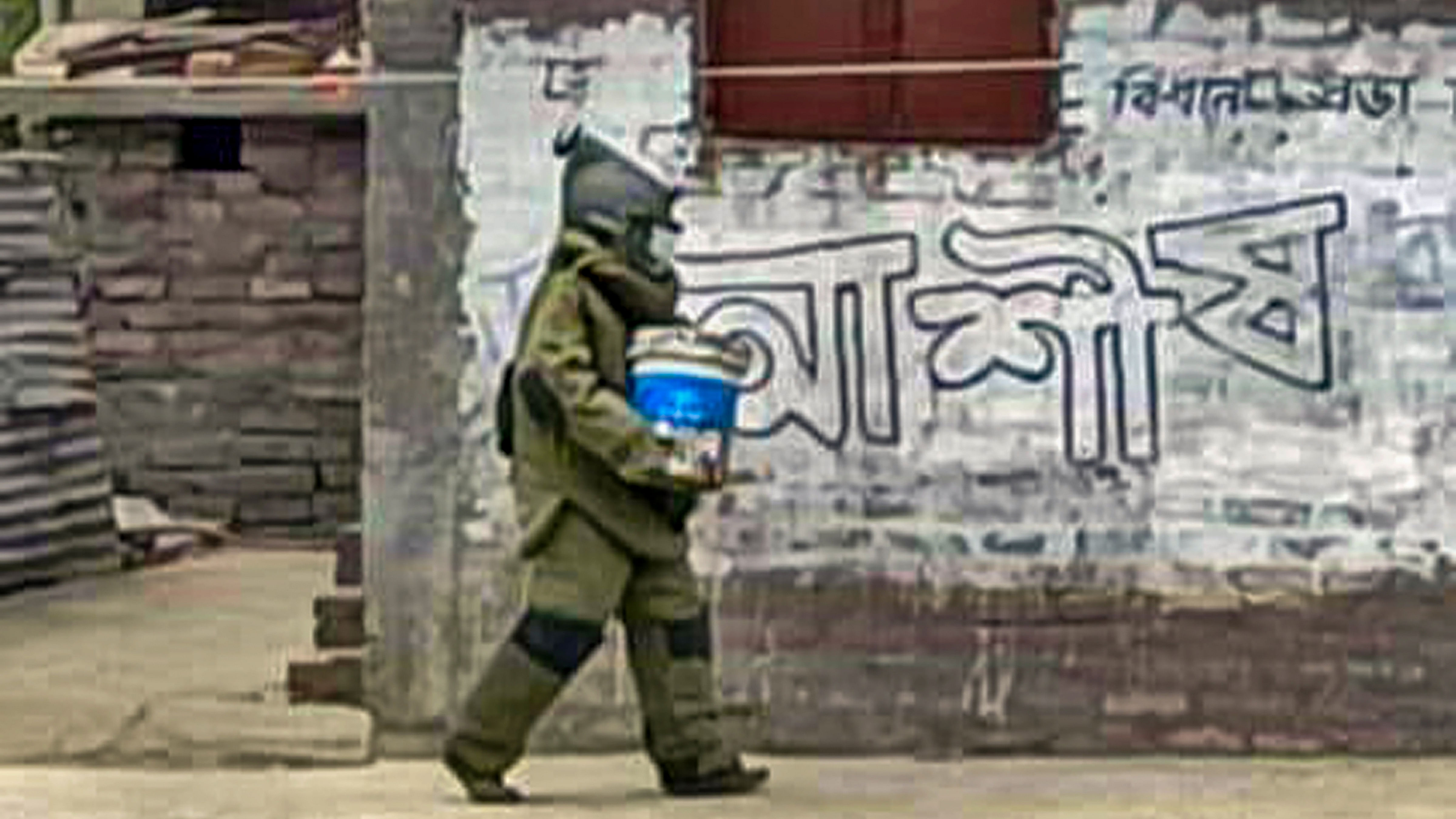 Bomb Squad personal carries the crude bombs recovered near the house of Palash Sheikh, the absconding accused in the TMC leader Bhadu Sheikh murder case, at Bogtui village in Birbhum district. Credit: PTI File Photo