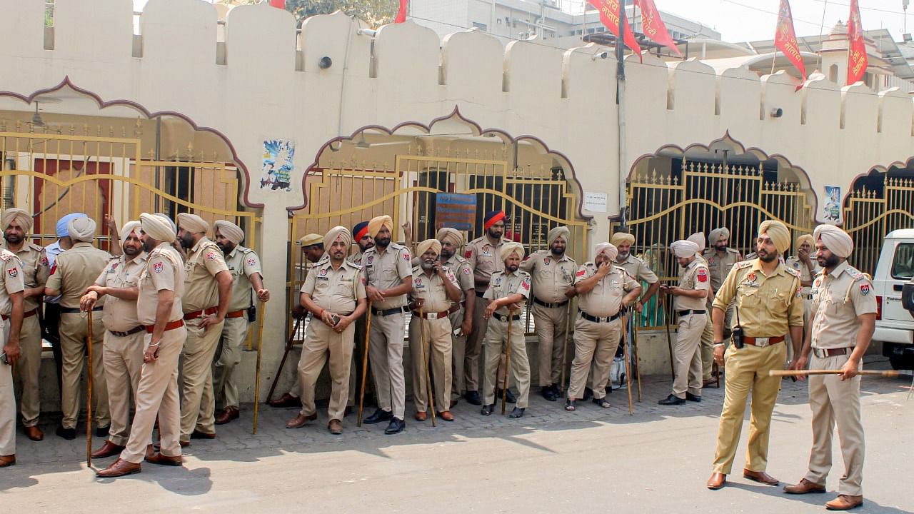 Security personnel stand guard outside Kali Mata temple, a day after clashes broke out between two groups, in Patiala. Credit: PTI Photo