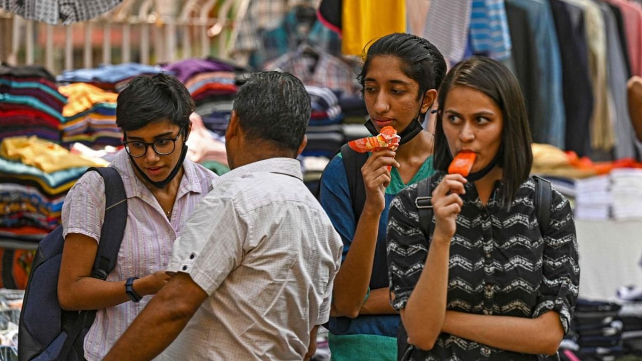 Girls have ice creams while shopping on a hot summer afternoon in New Delhi. Credit: AFP Photo