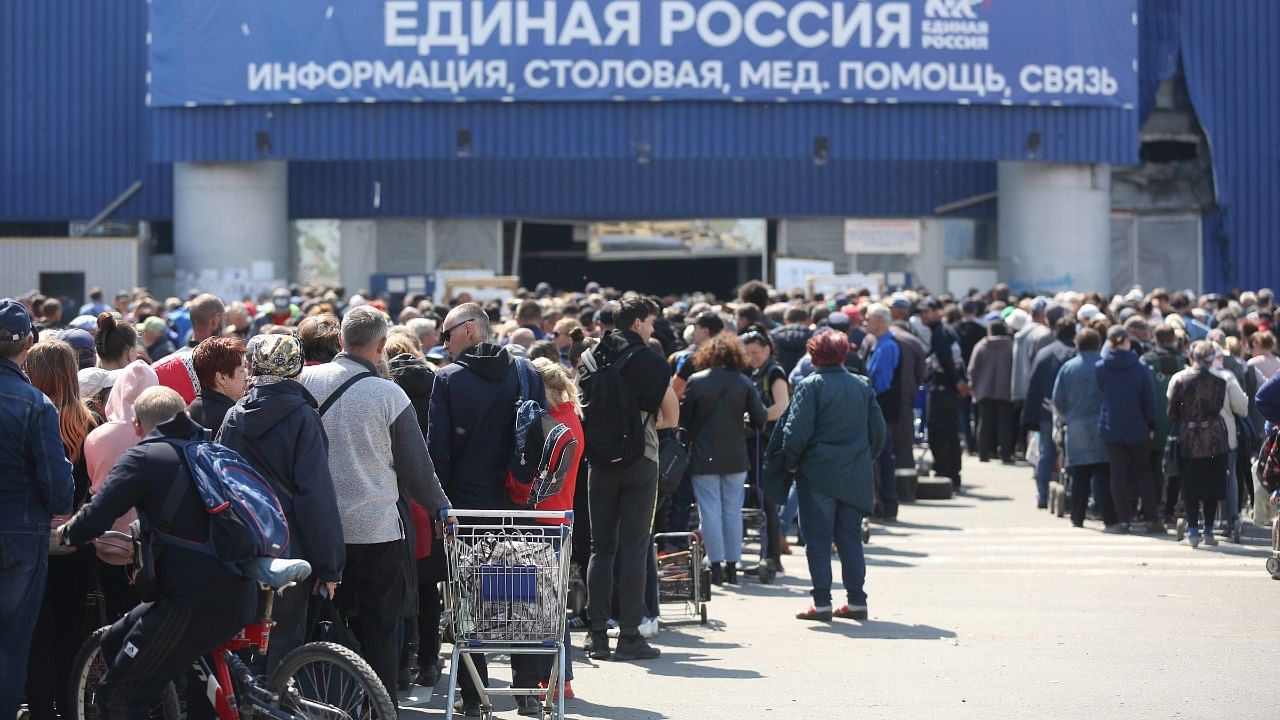 Local civilians line up to get humanitarian aid distributed in the United Humanitarian Center in Mariupol. Credit: AP/PTI Photo