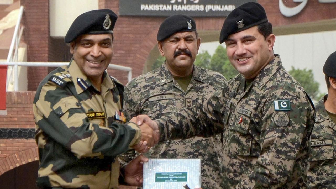 order Security Force (BSF) Commandant Jasbir Singh presents sweets to Pakistani Rangers Wing Commander Aamir on the occasion of the Eid al-Fitr festival. Credit: PTI Photo