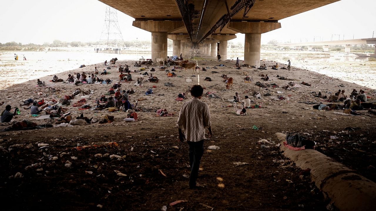 People sleep on the Yamuna river bed under a bridge on a hot summer day in New Delhi. Credit: Reuters Photo