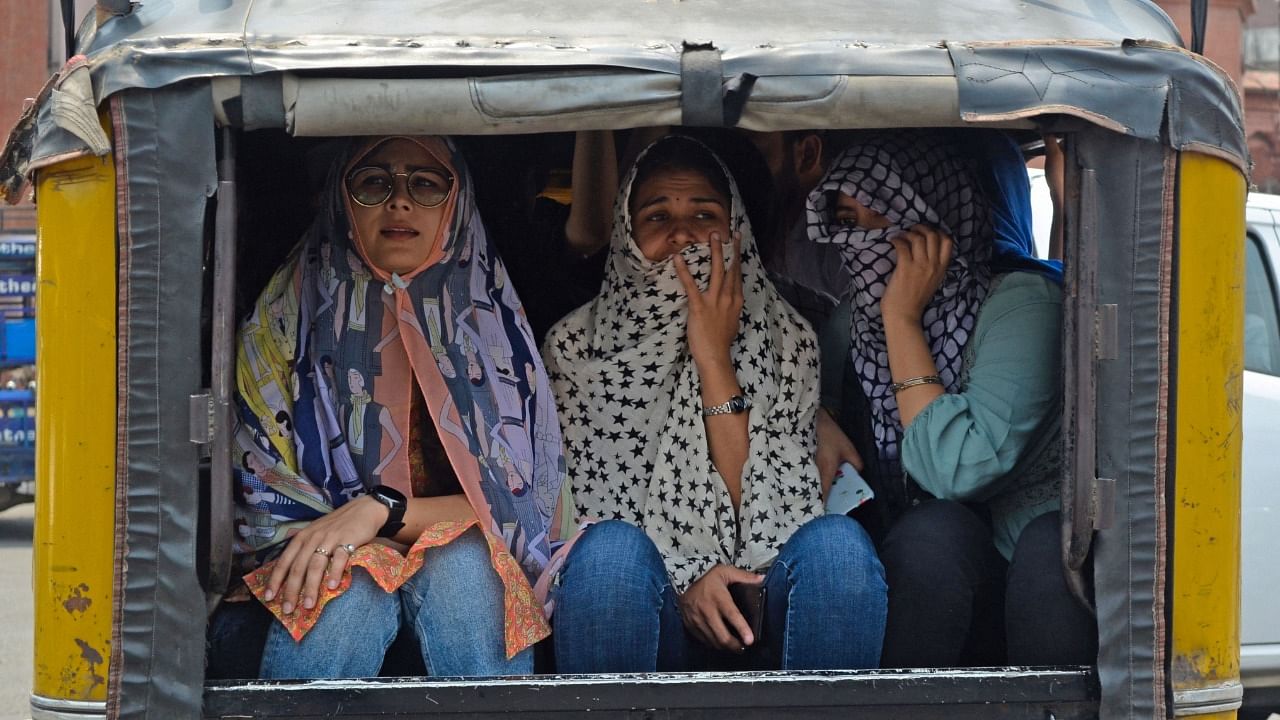 Women cover their faces with cloth while travelling in an autorickshaw on a hot summer day in Amritsar. Credit: AFP Photo