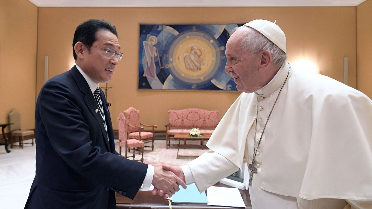 Pope Francis shake hands with Japanese Prime Minister Fumio Kishida during a private audience at the Vatican. Credit: AFP Photo