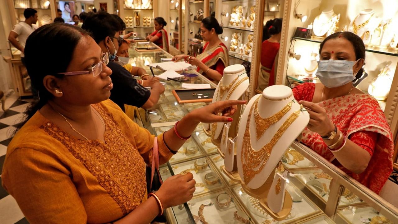 A customer checks a gold necklace before buying it at a jewellery showroom on the occasion of Akshaya Tritiya, a major gold buying festival, in Kolkata. Credit: Reuters photo
