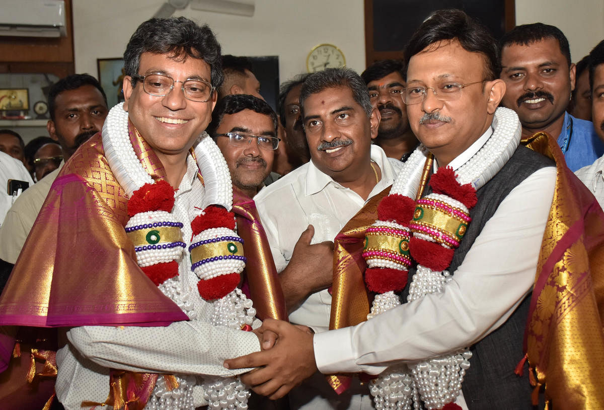 Gaurav Gupta congratulates newly appointed (left) BBMP Chief Commissioner Tushar Girinath on Friday. DH Photo/B K Janardhan
