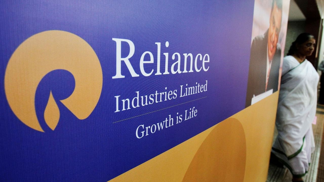A woman walks past a poster of Reliance Industries. Credit: Reuters Photo