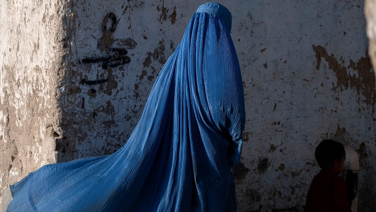 An Afghan burqa-clad woman walks with a child in Kabul. Credit: AFP Photo