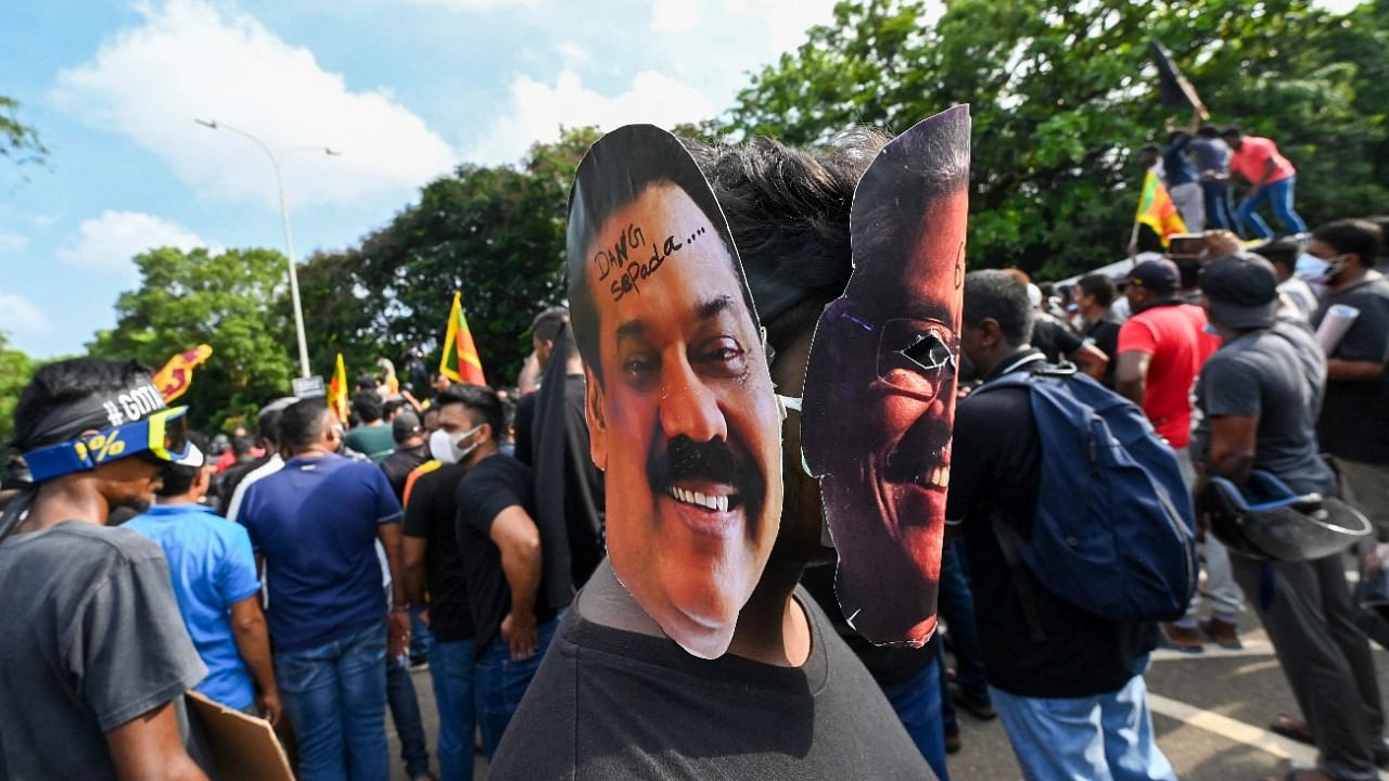 A demonstrator wearing masks of Sri Lanka's President Gotabaya Rajapaksa (R) and Prime Minister Mahinda Rajapaksa takes part in a demonstration in Colombo. Credit: AFP Photo