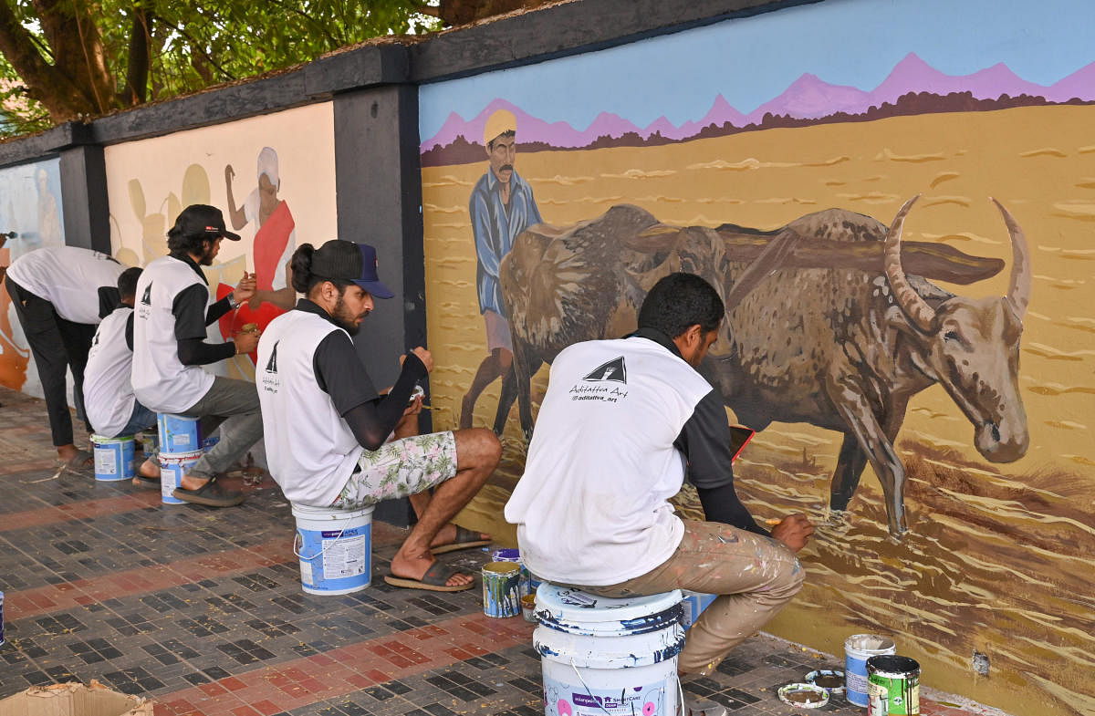 Members of the Aditatva Arts team work on murals to unravel age-old agrarian practices in Dakshina Kannada district. DH Photo/Irshad Mahammad