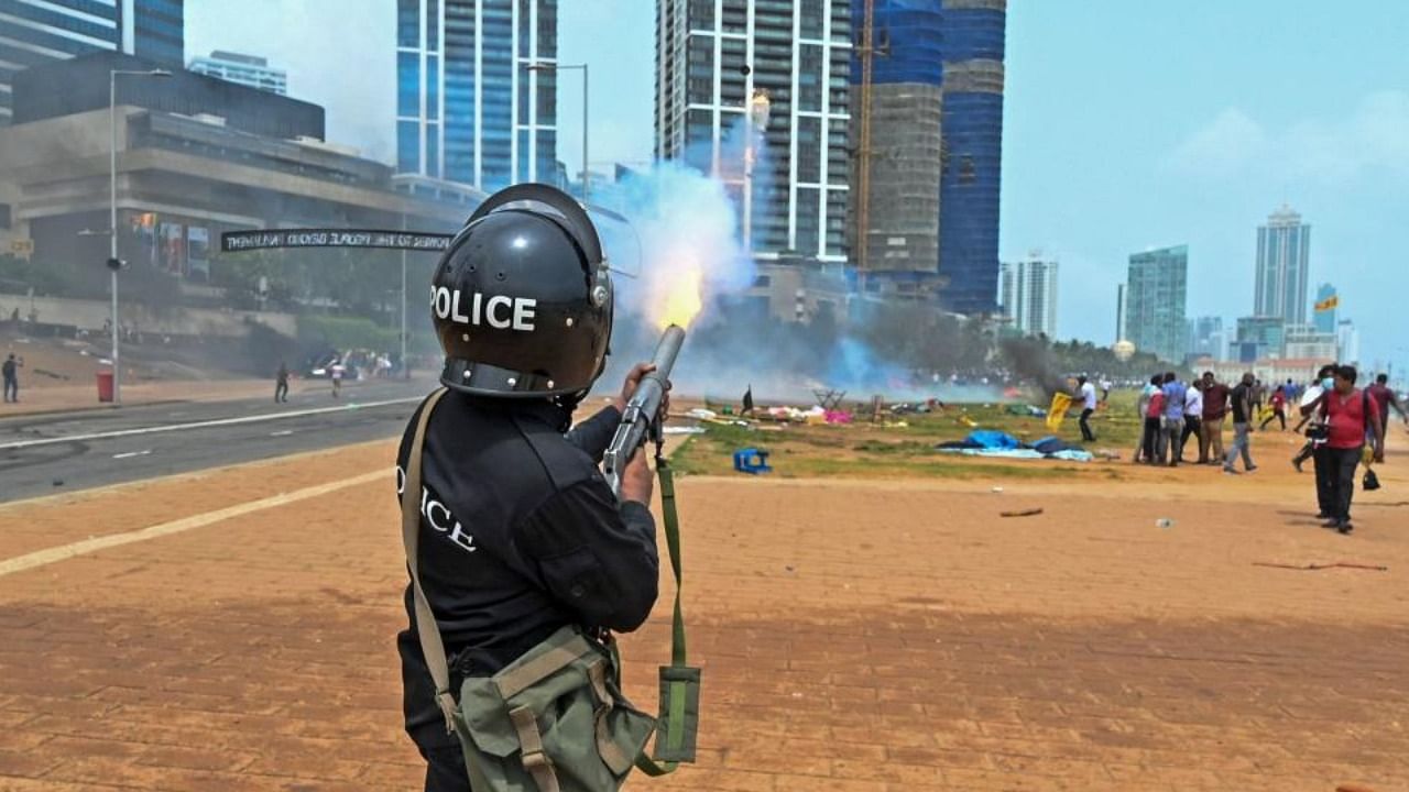 A policeman fires tear gas during a clash between government supporters and demonstrators outside the President's office in Colombo on May 9, 2022. Credit: AFP Photo