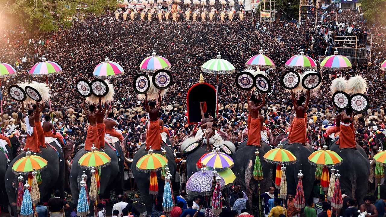 Devotees witness umbrella showing competition by Thiruvambadi and Paramekkavu Devaswams in connection with the famous 'Thrissur Pooram'. Credit: PTI Photo