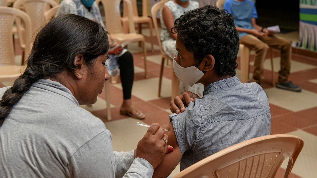 A health worker inoculates a school student with a dose of ‘Corbevax’ vaccine during a vaccination drive held for children in the age group of 12-14, as a preventive measure against Covid-19. Credit: AFP Photo
