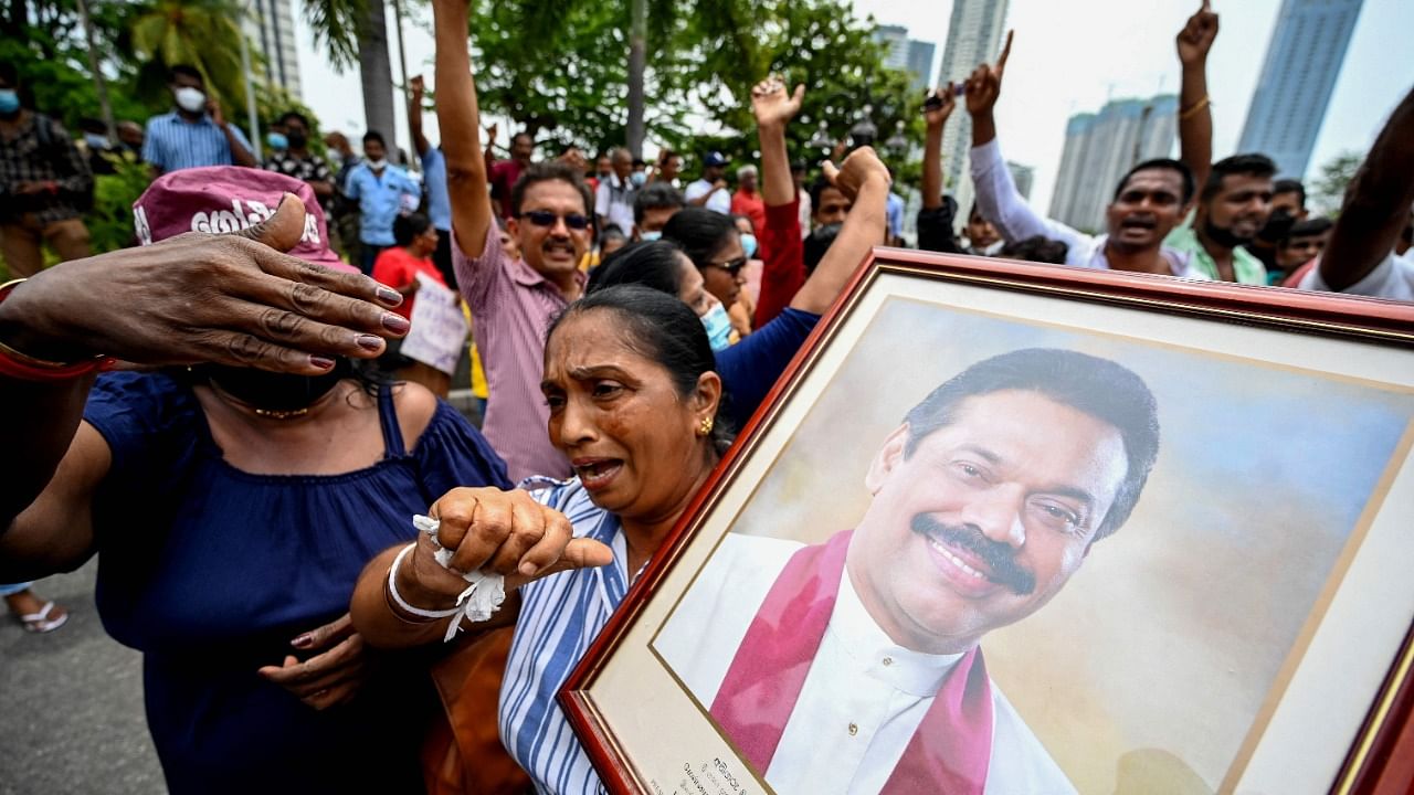 Pro-government supporters hold Prime Minister Mahinda Rajapaksa's portrait while protesting outside the prime minister’s residence in Colombo. Crtedit: AFP Photo