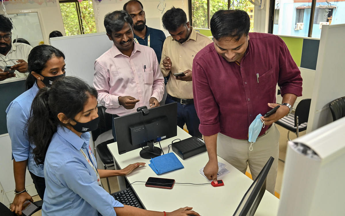Deputy Commissioner Dr Rajendra K V gives his thumb impression for authentication to get a copy of Aadhaar card at the Aadhaar Seva Kendra operated by the Unique Identification Authority of India, in Mangaluru, on Tuesday. DH Photo