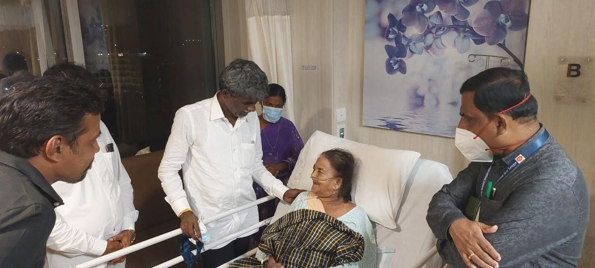 Minister Kota Srinivas Poojary visits Padma Shri awardee Halakki tribal folk artiste Sukri Bommagowda at a hospital in Mangaluru.