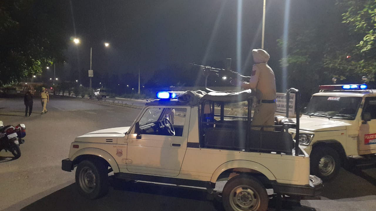 A police personnel atop a vehicle stands guard after a blast outside the Punjab Police's intelligence department office in Mohali. Credit: PTI Photo