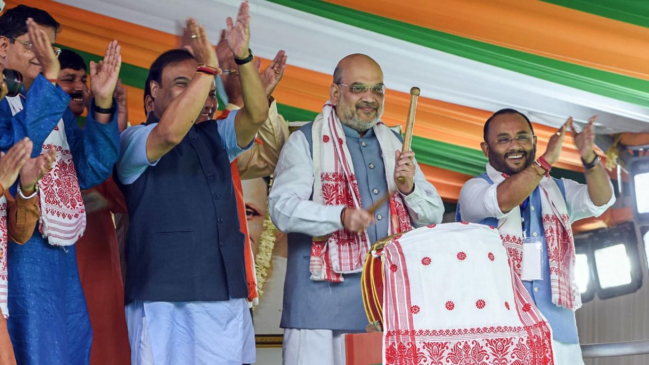 Union Home Minister Amit Shah beats a 'Nagara' (drum) during a public meeting organized to celebrate the completion of one year of Himanta Biswa Sarma led BJP government, in Guwahati. Credit: PTI Photo