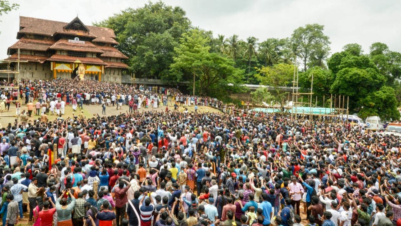 Devotees during the opening of the door of the southern 'Gopuram' of the Vadakkumnathan temple to mark the beginning of the Thrissur Pooram festival, in Thrissur. Credit: PTI Photo
