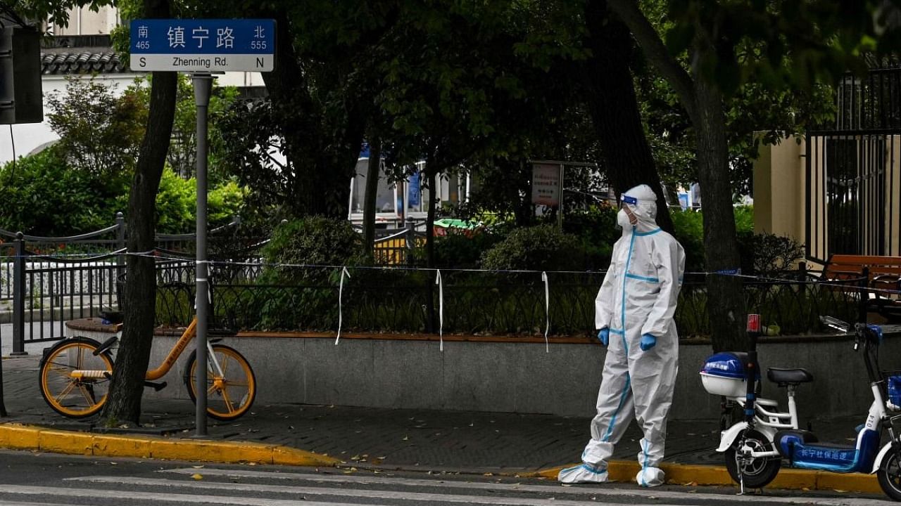 This photo taken on May 10, 2022 shows a worker standing on a street during a Covid-19 coronavirus lockdown in the Jing'an district in Shanghai. Credit: AFP Photo