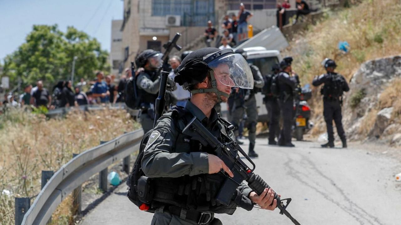 Israeli security forces keep watch during scuffles with Palestinians in the Arab east Jerusalem neighbourhood of Silwan as Israeli machinery demolish a Palestinian house at the site on May 10, 2022. Credit: AFP Photo