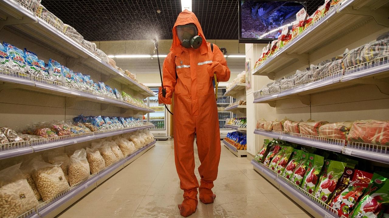 A health official sprays disinfectant as part of preventative measures against Covid-19, in the Daesong Department Store in Pyongyang. Credit: AFP File Photo