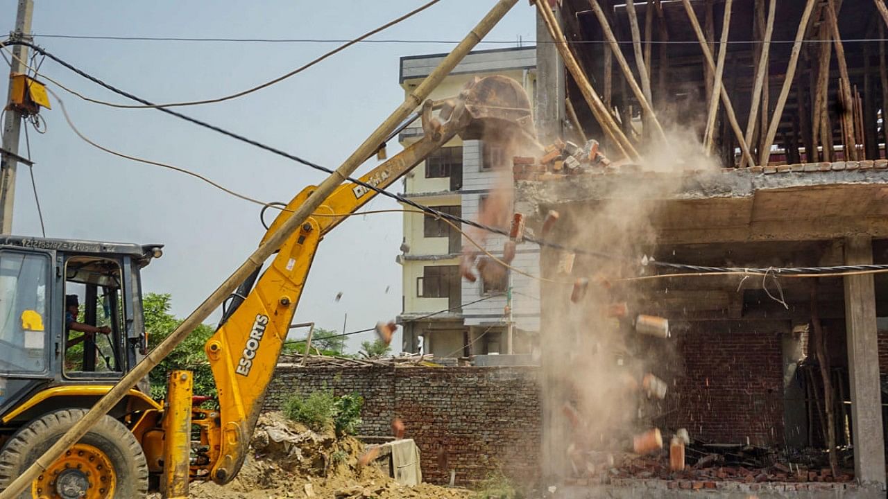 MCD workers use bulldozers to demolish illegal structures during an anti-encroachment drive, in New Delhi. Credit: PTI Photo