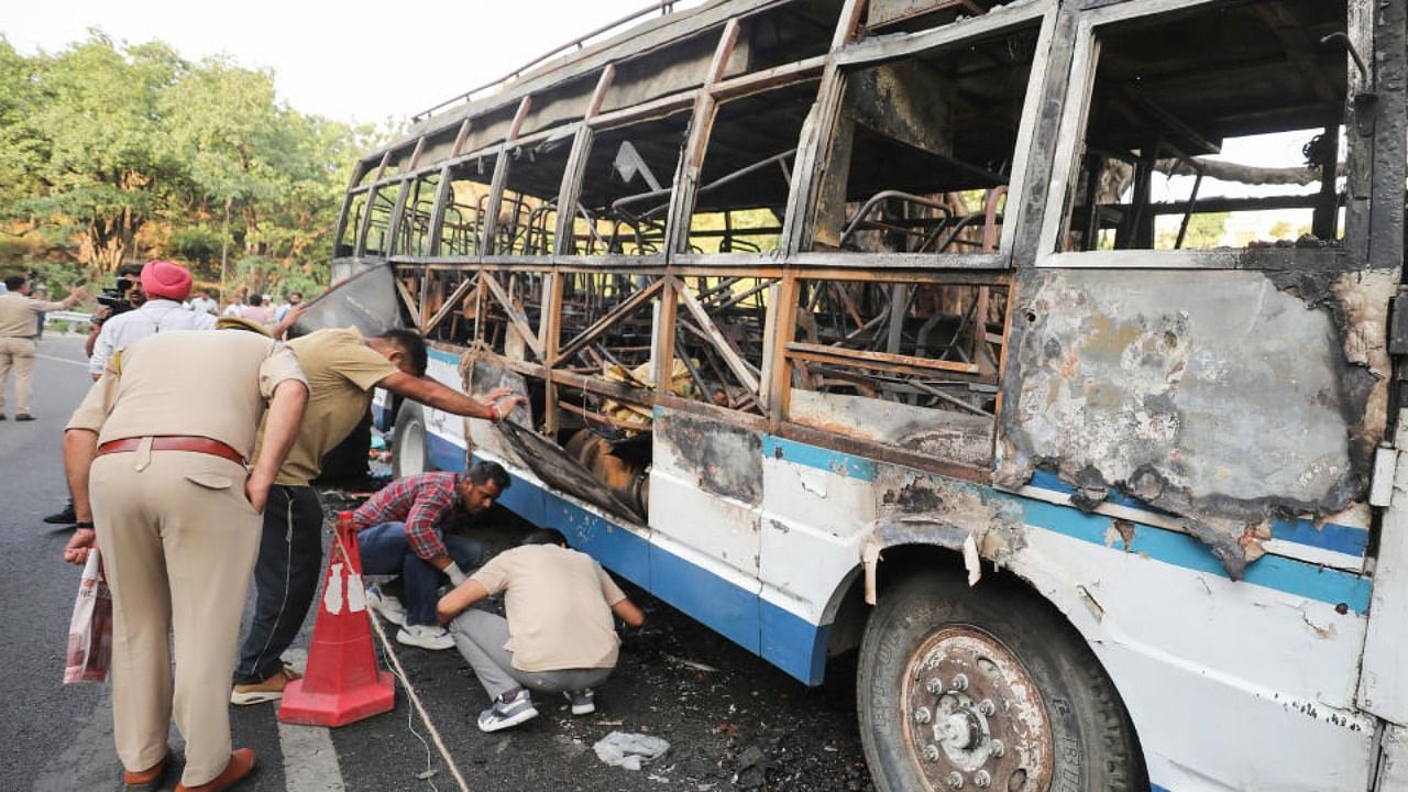 Police personnel and forensic experts inspect the charred remains of a bus that caught fire on its way from Mata Vaishno Devi Shrine base camp to Jammu, in Katra, Friday, May 13, 2022. Credit: PTI Photo