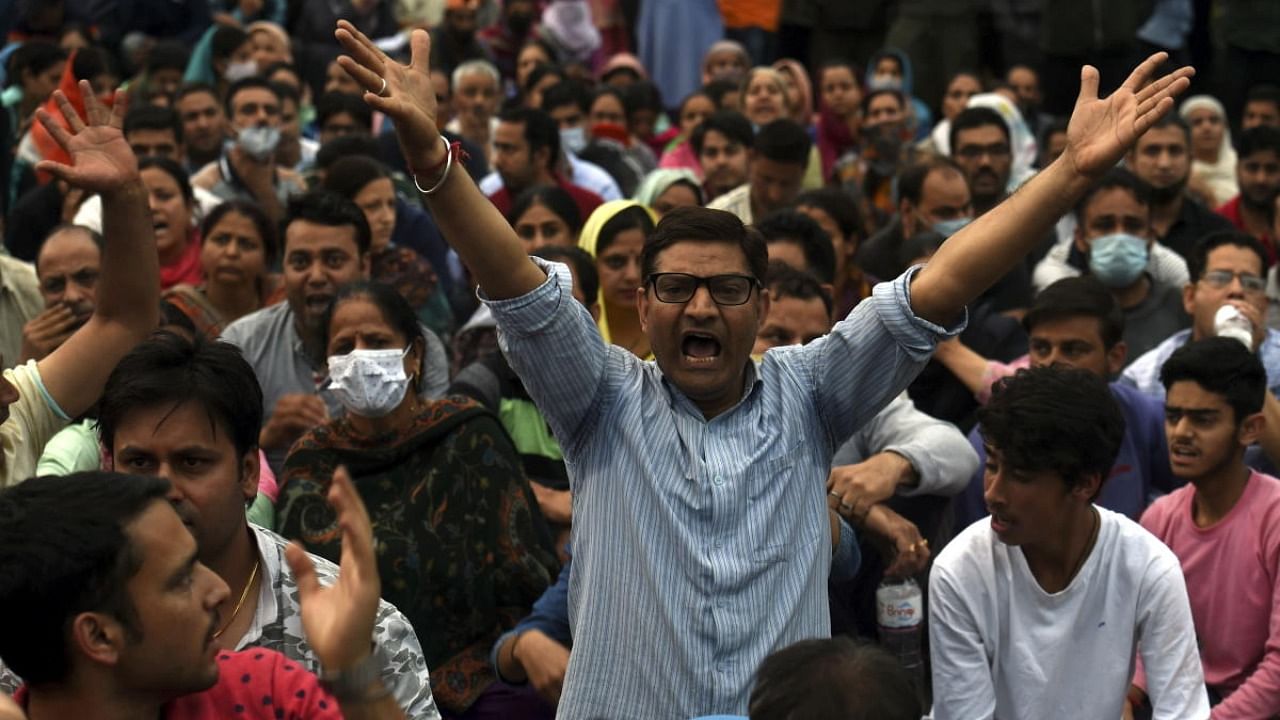 Kashmiri pandits shout slogans while blocking a road during their protest over the killing of Rahul Bhat, who was shot at by militants inside his office and later succumbed to injuries, at Sheikh Pora in Budgam district, Thursday, May 12, 2022. Credit: PTI Photo