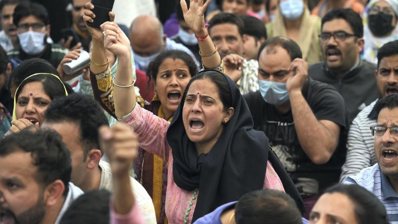 Kashmiri pandits shout slogans while blocking a road during their protest over the killing of Rahul Bhat, who was shot at by militants inside his office and later succumbed to injuries, at Sheikh Pora in Budgam district. Credit: PTI photo