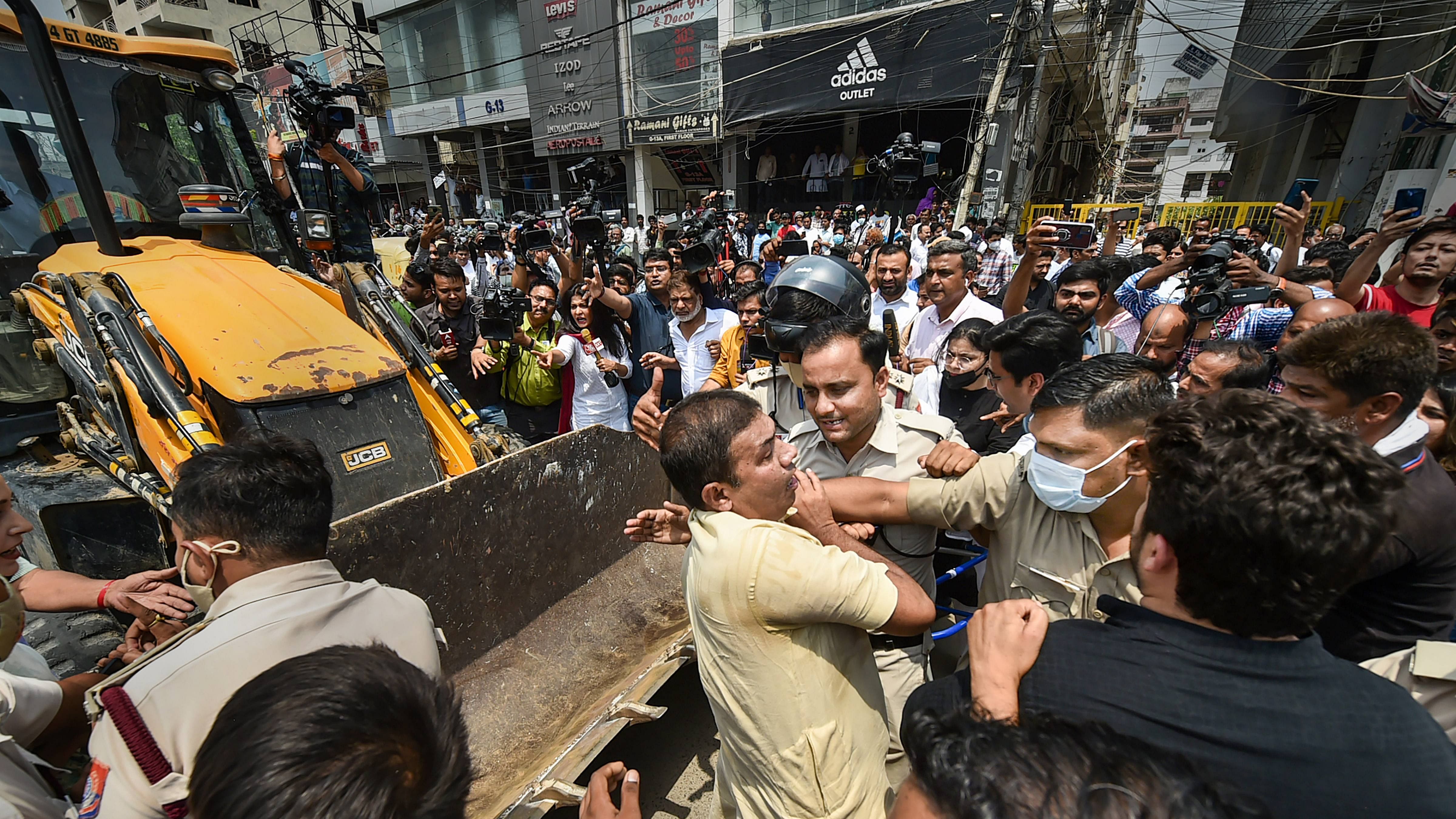 Delhi Police personnel attempt to stop locals staging a protest in front of a Municipal Corporation of Delhi (MCD) bulldozer at Shaheen Bagh area, during an anti-encroachment drive, in New Delhi. Credit: PTI Photo