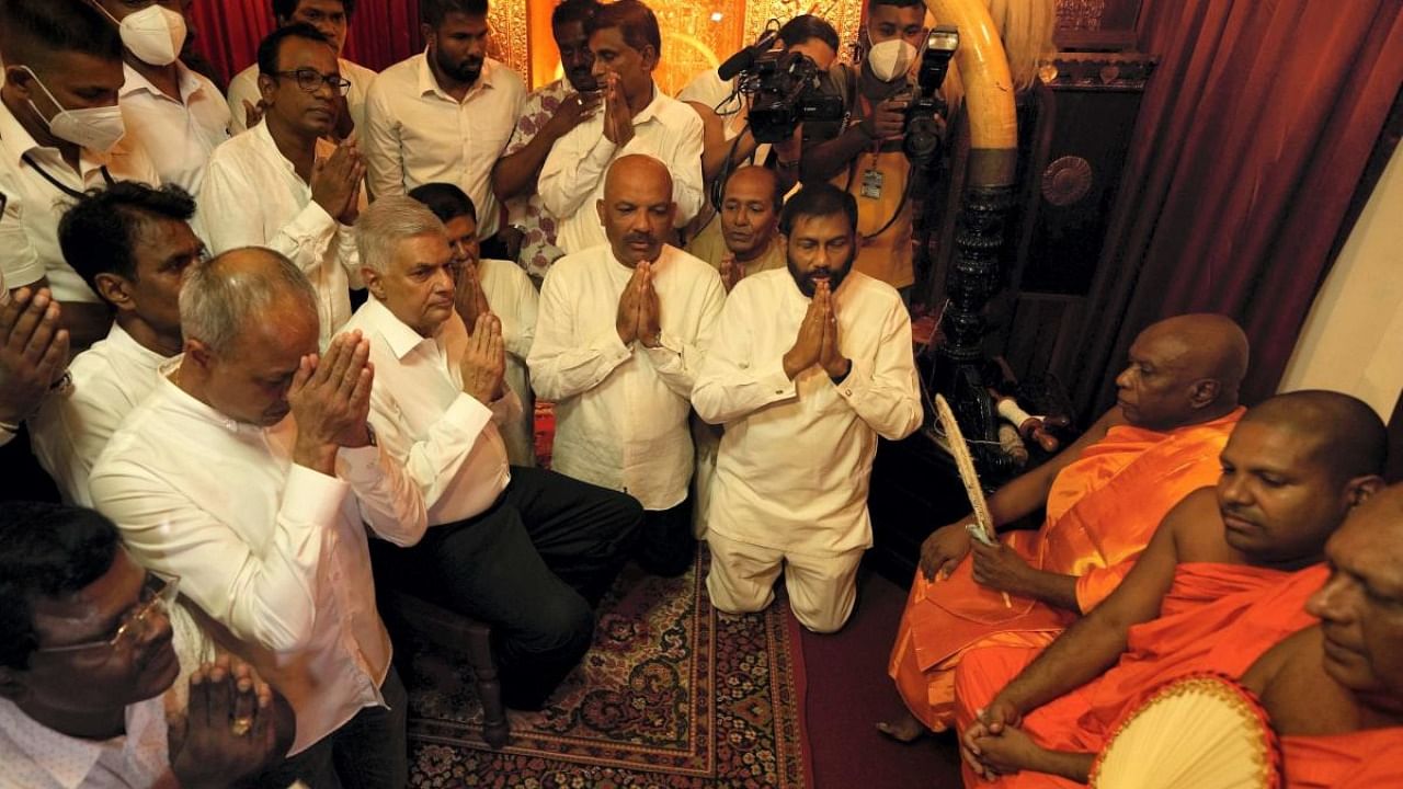 Sri Lanka's new prime minister Ranil Wickremesinghe, third left, takes part in religious observances at a temple in Colombo. Credit: AFP Photo