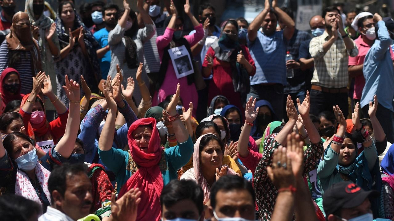 Demonstrators schout slogans during a protest against the killing of a government employee belonging to the Kashmiri Pandit community on the outskirts of Srinagar