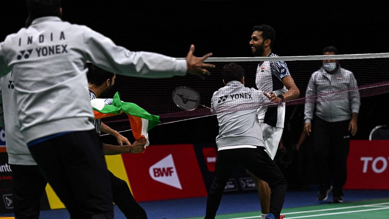 Members of India’s badminton team celebrate after India’s H.S. Prannoy (R) won against Denmark’s Rasmus Gemke during the semifinals of the Thomas and Uber Cup badminton tournament in Bangkok. Credit: AFP Photo