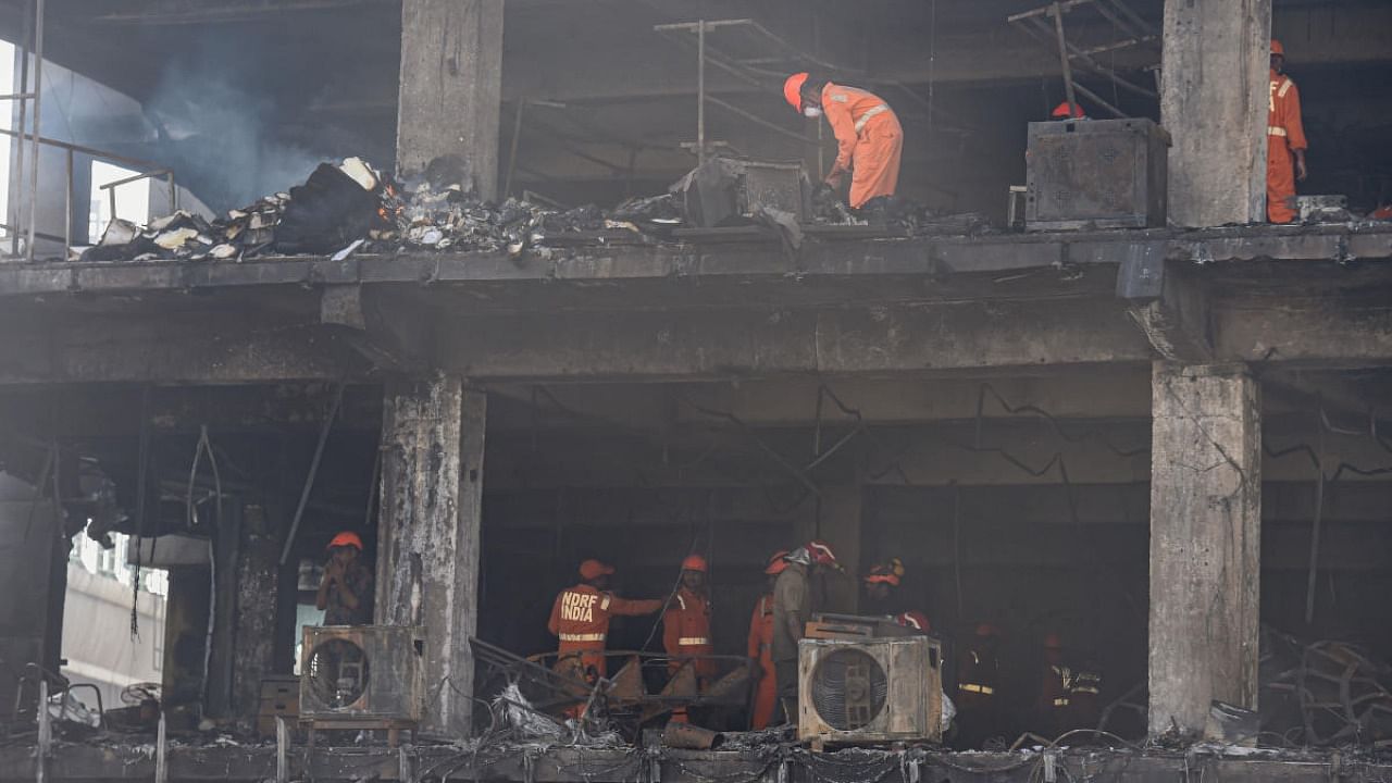 NDRF personnel during rescue and relief work after a massive fire at an office building near the Mundka Metro Station, in West Delhi. Credit: PTI Photo