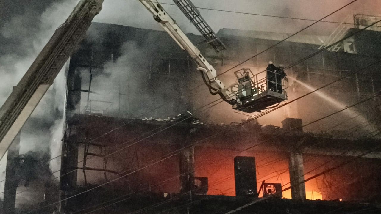 Firefighters try to douse a fire which broke out in a building at Mundka, in West Delhi. Credit: PTI Photo