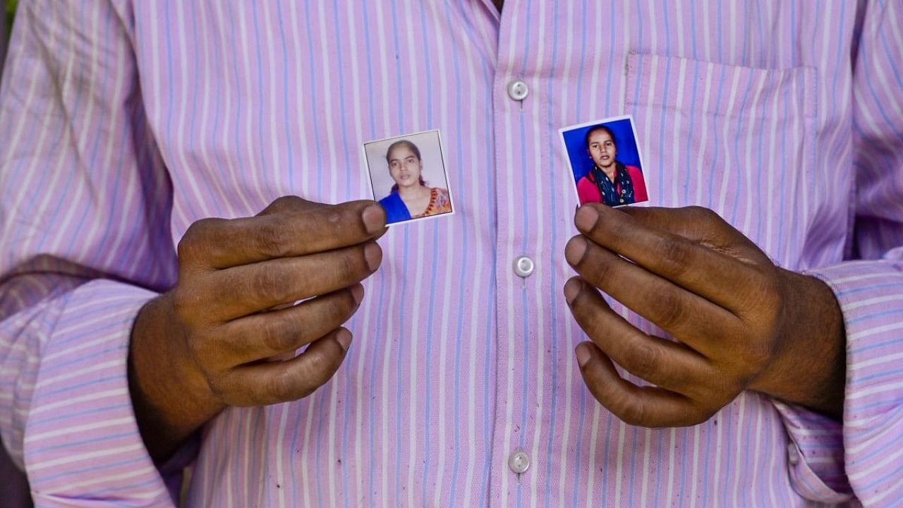 Mahipal Singh, father of two missing girls (Priti 23, and Poonam 20), shows photos to media person at Sanjay Gandhi Memorial Hospital in New Delhi