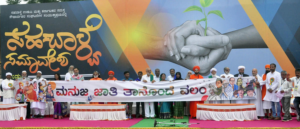 Dignitaries at the ‘Samarasya Nadige’ (harmony walk) and convention unveil a banner which reads ‘Manuja Jathi Thanonde Valam’ in Udupi.