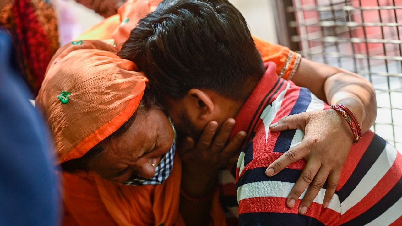 Family members of the people missing after a massive fire at an office building near the Mundka metro station, react as they wait at Sanjay Gandhi Memorial Hospital in New Delhi. Credit: PTI Photo