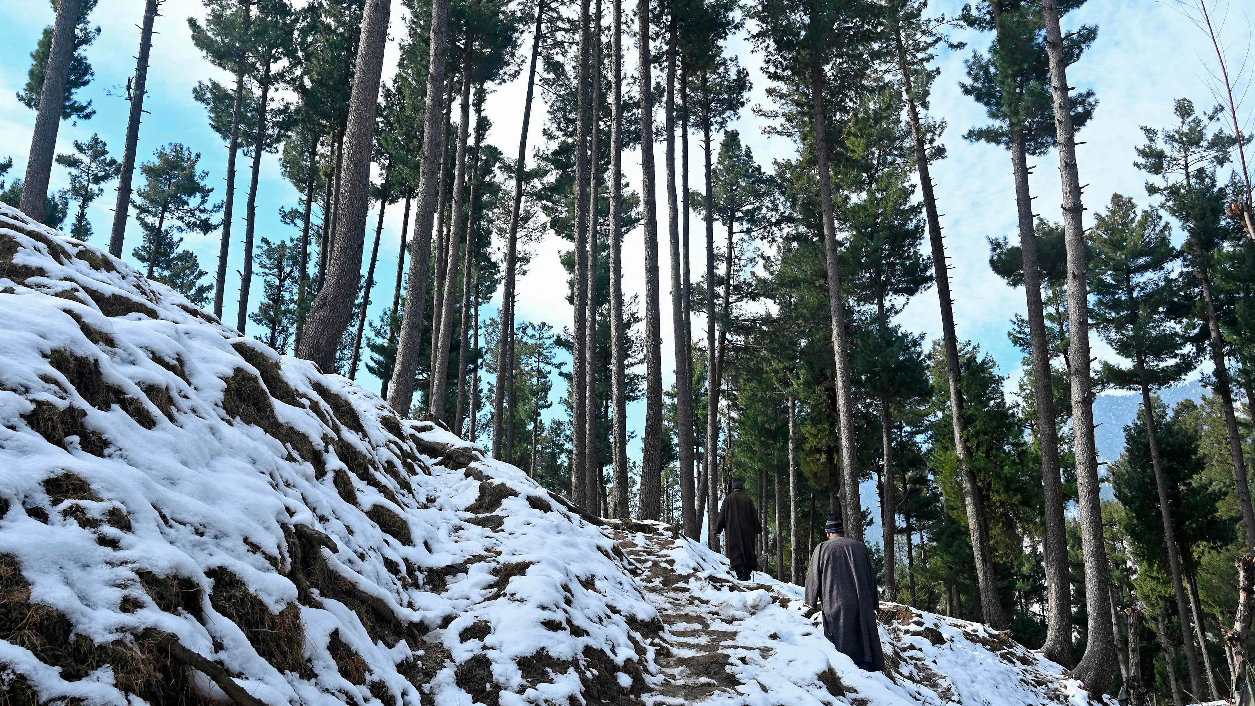 eople walk on a snow-covered at Pahalgam. Credit: AFP Photo