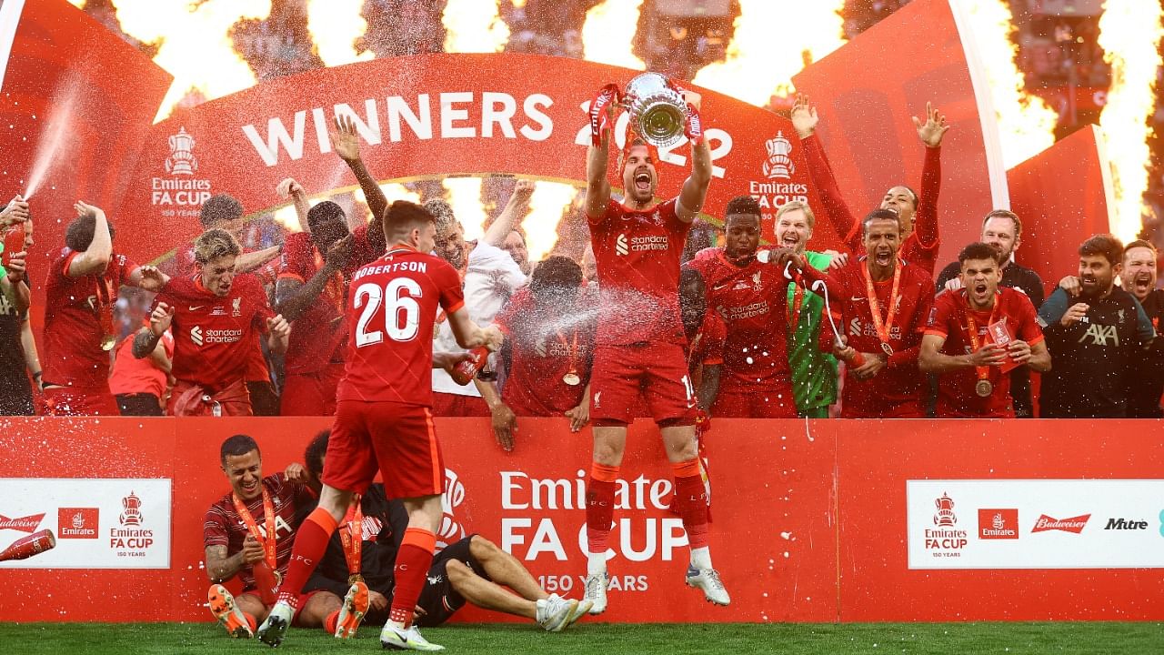 Liverpool's Jordan Henderson lifts the trophy as they celebrate after winning the FA Cup. Credit: Reuters Photo